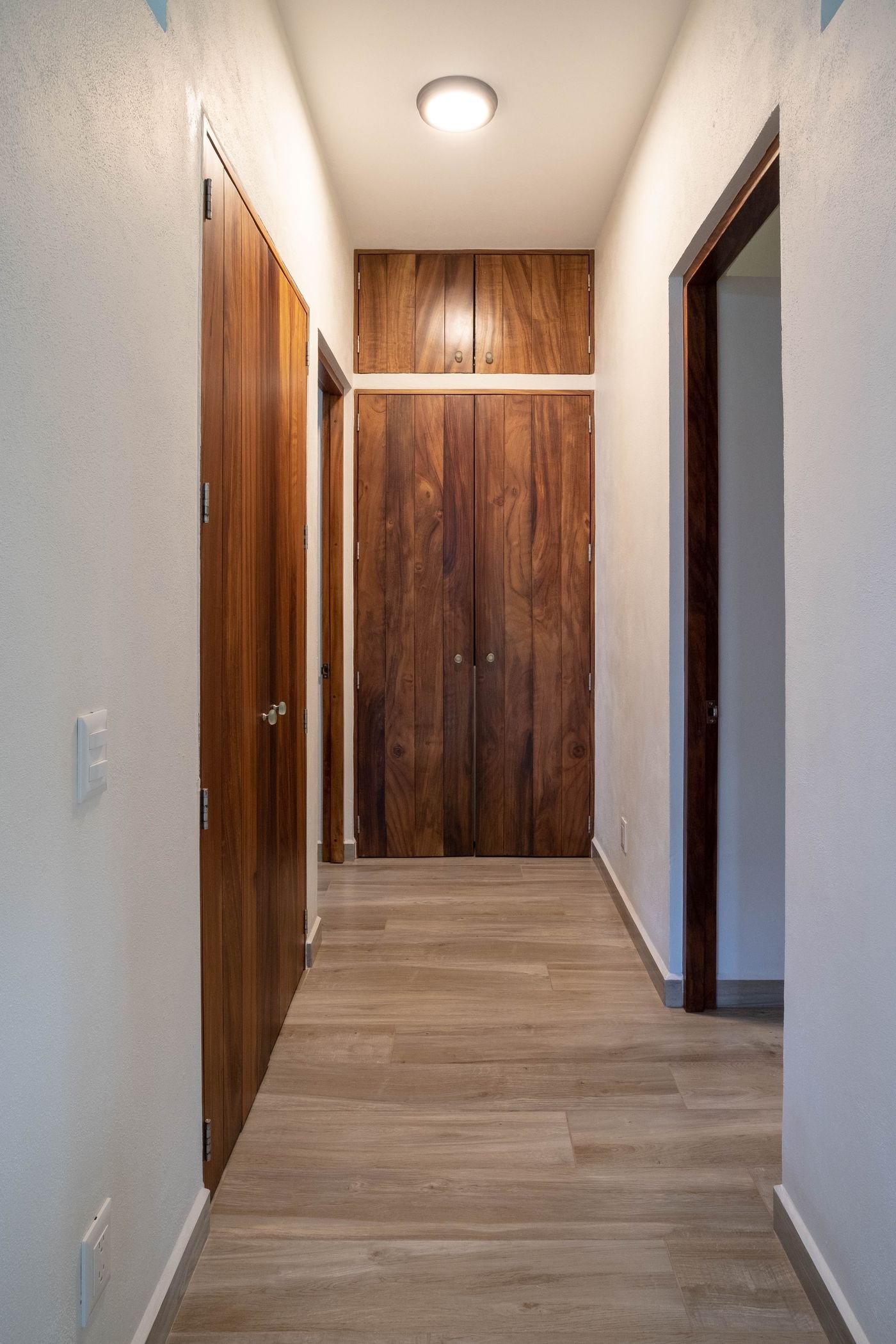 Hallway at Casa Nisha lined with solid parota wood doors and storage